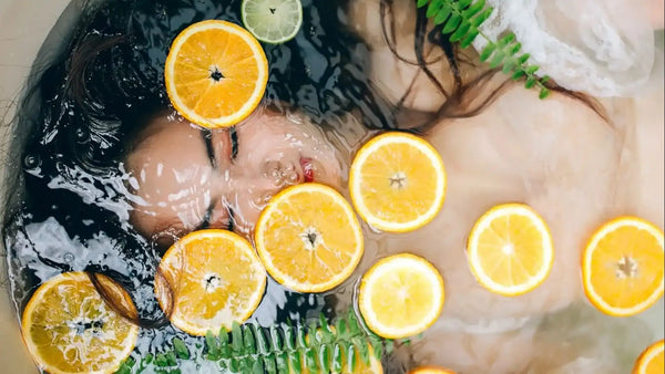 asian woman taking a bath with citrus fruits