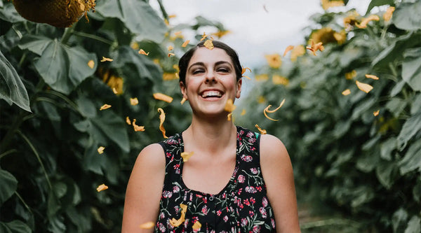 Girl smiling to a blast of yellow flowers