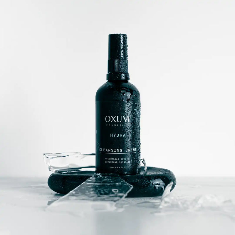 Oxum Cleansing Creme bottle standing on ice