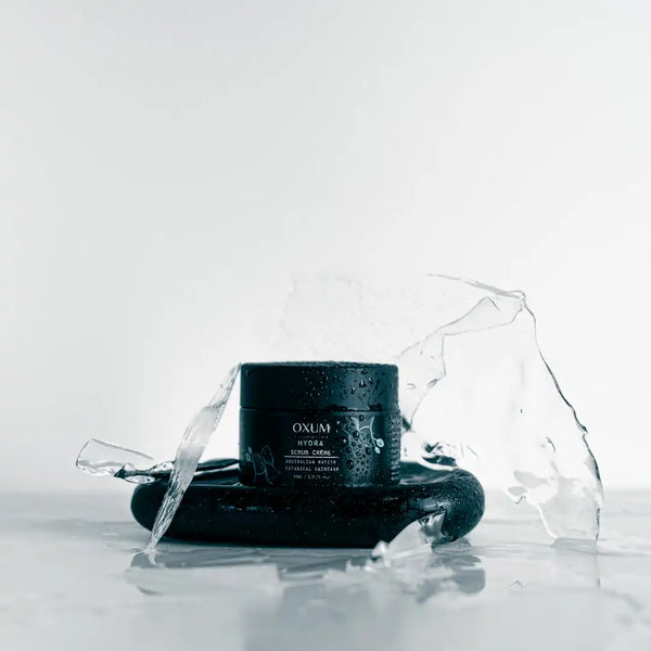 Scrub cream jar standing on black stone and ice